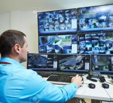 A security man watching CCTV footages of all the areas of building through monitor